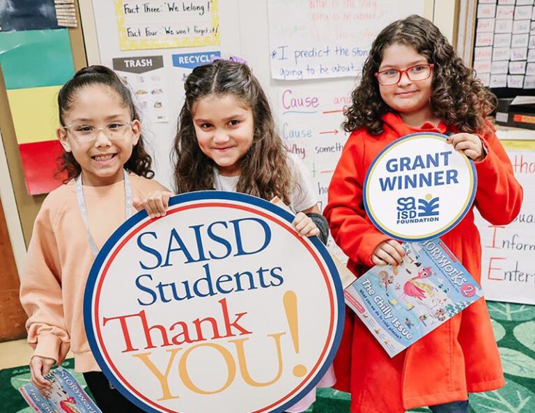Three students holding a "SAISD students thank you" sign